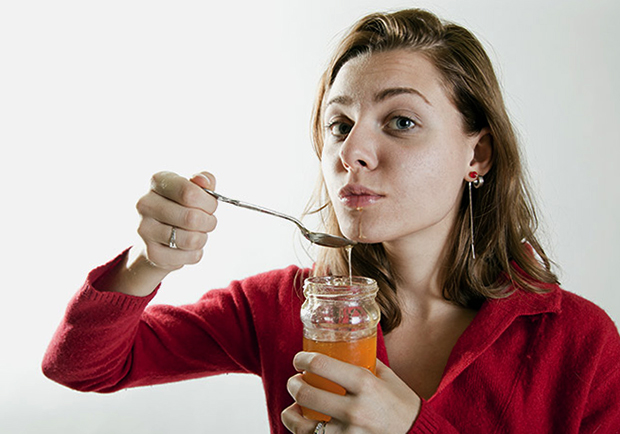 Женщина кушает мед